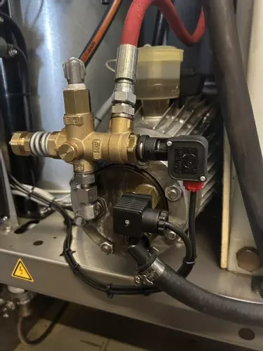 Over-temperature protection system installed on a Nilfisk SH Truck Booster pump to prevent overheating. The system monitors pump head temperature and automatically shuts the machine down if it exceeds safe operating limits, protecting seals and internal c